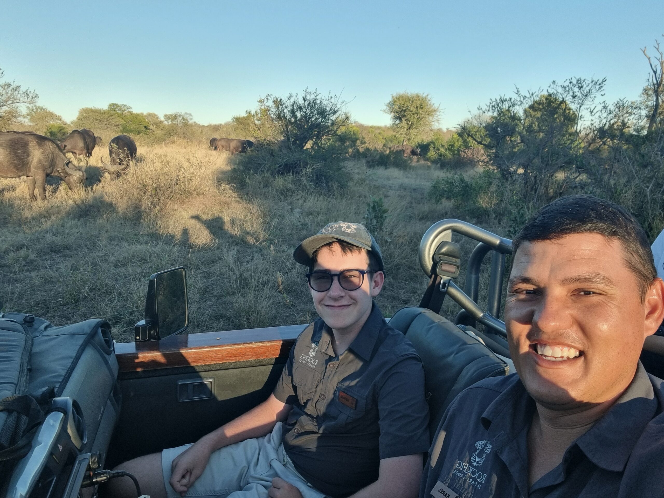 Head Guide Karel and George on a game drive with buffalo grazing in the background