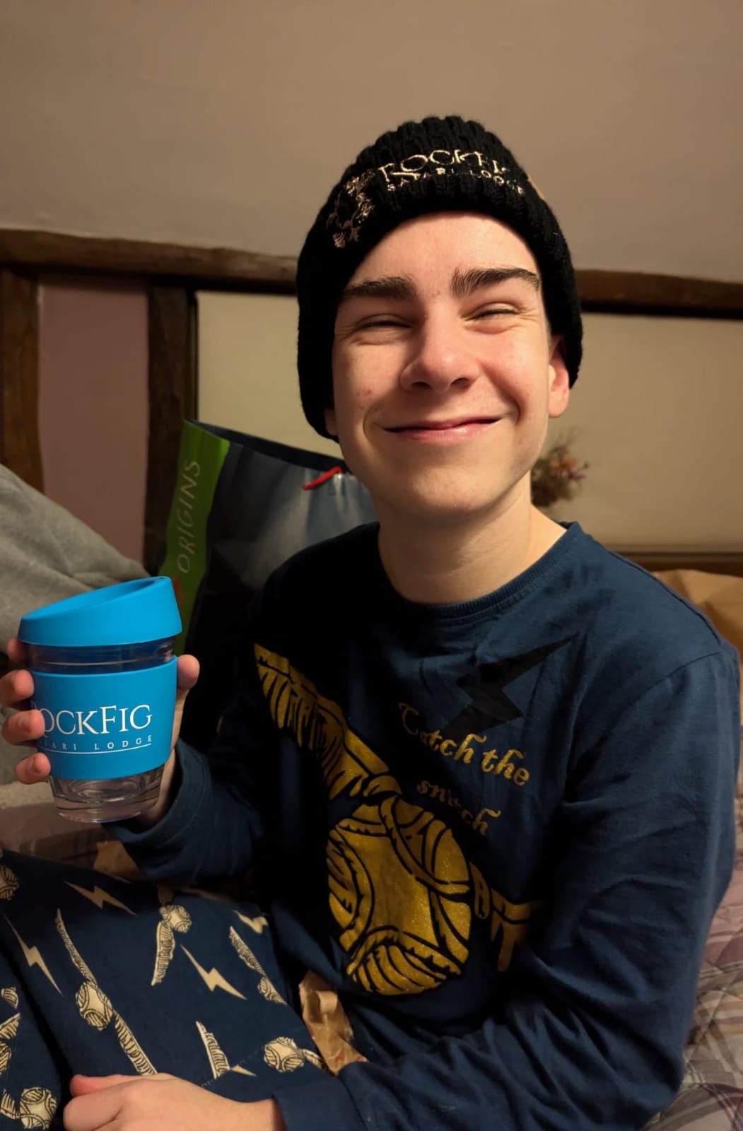 George at home wearing a Rockfig beanie and holding a Rockfig travel cup